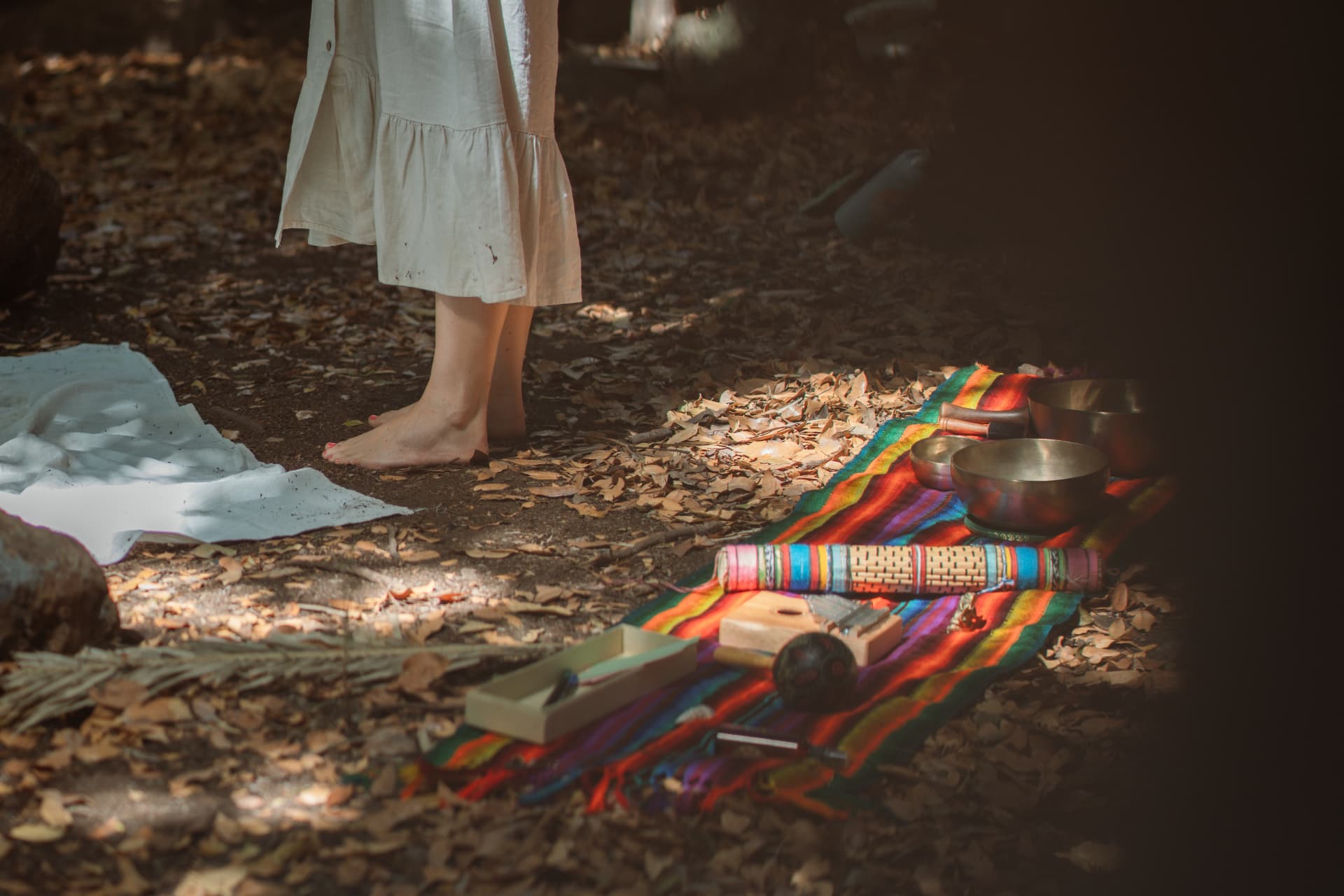 Ritualplatz im Wald mit bunten Tüchern und Klangschalen